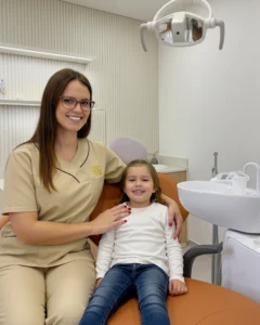 Dra. Diana Garcia, médica dentista da Mediminho em Braga, com uma criança durante uma consulta de odontopediatria num ambiente tranquilo e acolhedor.