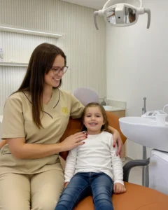 Dra. Diana Garcia, médica dentista da Mediminho em Braga, com uma criança durante uma consulta de odontopediatria num ambiente tranquilo e acolhedor.