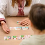 Close-up de uma atividade de Terapia da Fala com cartas ilustradas, durante sessão infantil na Mediminho, em Braga.